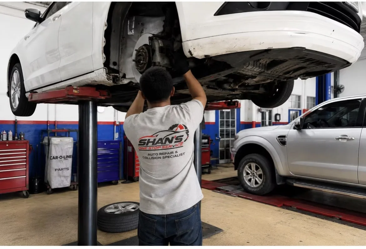 Shan’s One Stop mechanic working beneath raised car